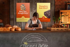Young brunette woman standing behind a counter in a bakery writing something on paper